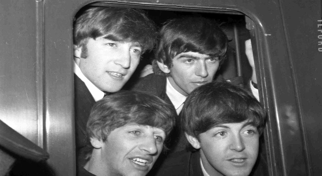 Los integrantes de los Beatles John Lennon y George Harrison, arriba de izquierda a derecha, Ringo Starr y Paul McCartney, abajo, posan en la ventana de un tren en la estación de Paddington en Londres.