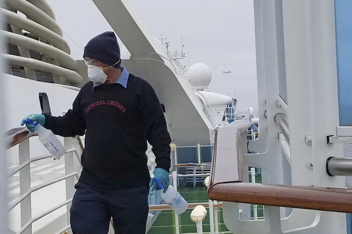En esta fotografía facilitada por Michele Smith, un empleado desinfecta un barandal en el crucero Grand Princess, anclado frente a la costa de California, el jueves 5 de marzo de 2020. Foto: Michele Smith vía AP