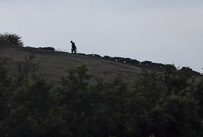 En esta imagen de archivo del 3 de octubre de 2019, la silueta de un patrullero voluntario fuertemente armado se ve recortada contra el horizonte en un puesto de francotirador sobre una colina, colocado para evitar incursiones del cártel Jalisco Nueva Generación, a las afueras de Tepalcatepec, estado de Michoacán, México. Foto: Marco Ugarte, Archivo, AP