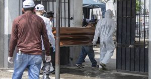 Empleados se disponen a enterrar los restos de una persona en el Cementerio General de Guayaquil, Ecuador, el 6 de abril del 2020. Guayaquil es uno de los principales focos de infección del COVID-19 de América Latina. Foto: Luis Pérez, AP. 