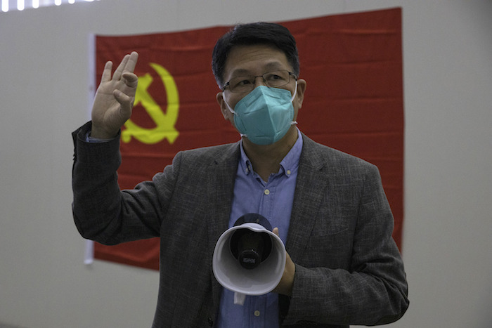 El doctor Zhan Junjian, extitular de uno de los tres hospitales temporales para atender coronavirus que se montaron en la ciudad, habla con la prensa con la bandera del Partido Comunista chino de fondo en Wuhan, provincia de Hubei, China, el jueves 9 de abril de 2020.