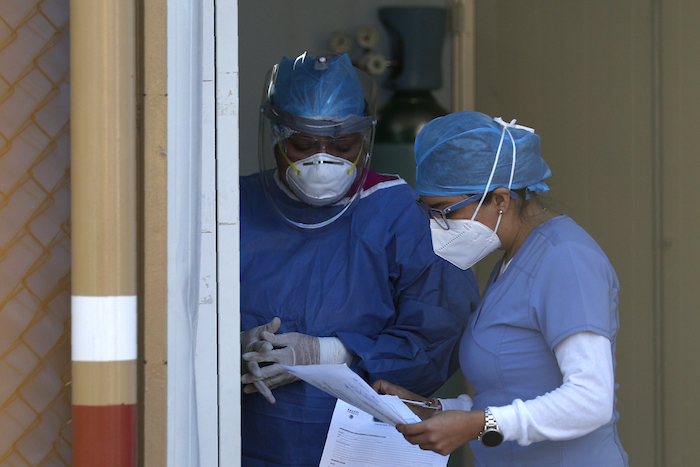 Trabajadores de la salud revisan papeleo a la entrada del área que trata COVID-19 en el Hospital General de México el martes 12 de mayo de 2020.