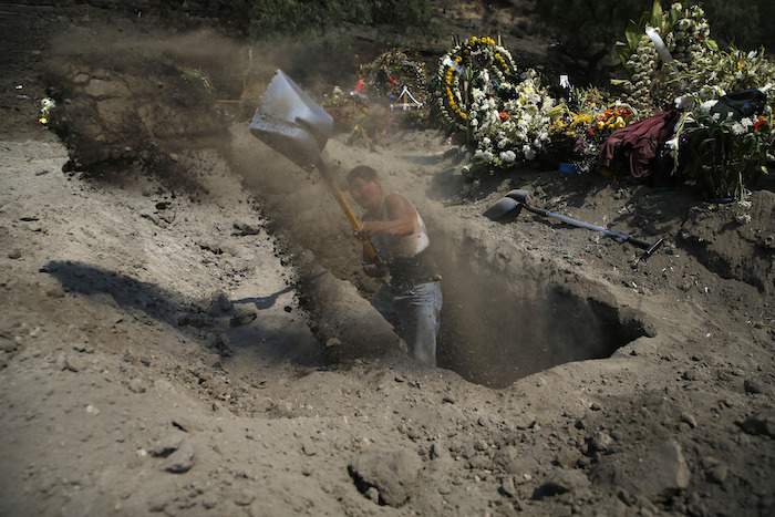 Trabajadores del panteón preparan las tumbas para los muertos por cononavirus en el Estado de Mexico. 