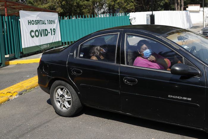 María Del Carmen Acero Camacho, de 48 años, a la derecha, deja el hospital junto con familiares después de una hospitalización de 21 días por COVID-19, en Iztapalapa, Ciudad de México, el lunes 25 de mayo de 2020. 