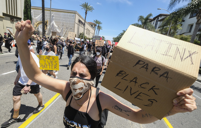 Una mujer sostiene un cartel durante una protesta por la muerte de George Floyd, en Los Ángeles, el sábado 30 de mayo de 2020. En todo Estados Unidos se registraron crecientes protestas tras la muerte de George Floyd, que murió tras ser reducido por policías de Minneapolis el 25 de mayo de 2020. 