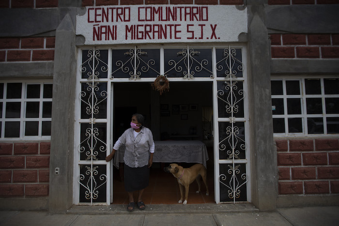 Clara Lara, cuyo hijo vive en Staten Island, Nueva York, en la puerta de la casa que su hijo construyó para cuando regrese, pero que mientras se emplea como centro comunitario, en San Jerónimo Xayacatlán, México, el 25 de junio de 2020.