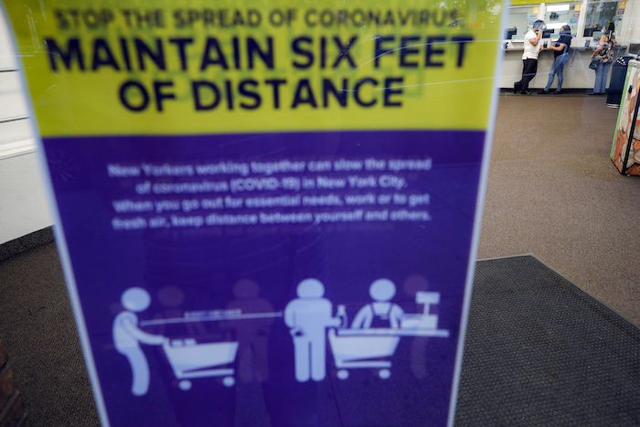 Magnolia Ortega (detrás, a la derecha), dentro de una oficina de Western Union con su esposo, Arturo Morales, y su hija Marlene, para enviar dinero a su familia en México, el 24 de junio de 2020, en Staten Island, Nueva York. Ortega perdió su empleo limpiando casas por la pandemia del coronavirus, lo que redujo sus remesas mensuales de 800 a 300 dólares.