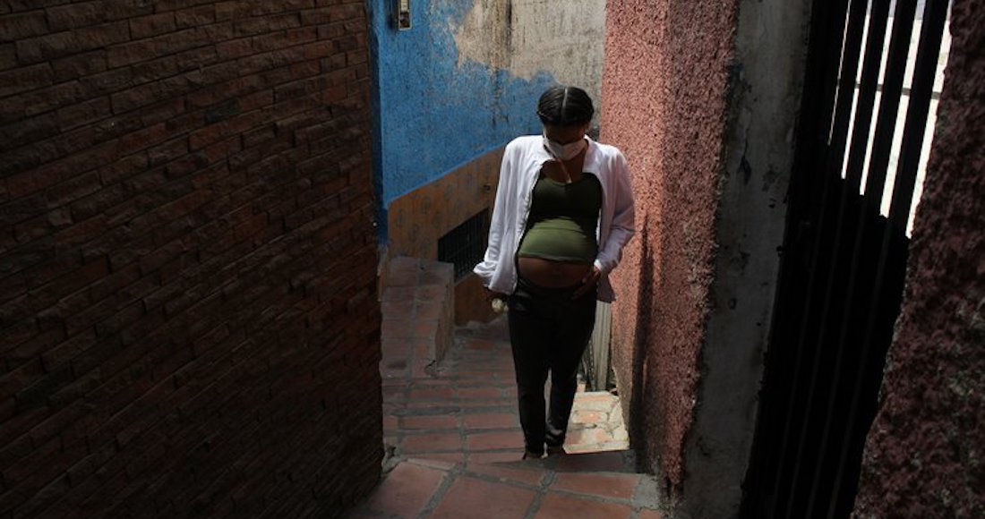 Una mujer embarazada camina en un vecindario de Caracas durante la cuarentena por la COVID-19.