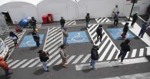 Personas mantienen sana distancia mientras esperan noticias de sus familiares, hospitalizados por COVID-19 en Ecuador. Foto: Dolores Ochoa, AP.