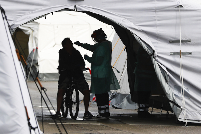 Una empleada de salud toma una muestra de un ciclista que se presentó como voluntario para una nueva prueba de coronavirus en la zona del Oktoberfest en Theresienwiese, el jueves 24 de septiembre de 2020 en Munich, Alemania. 