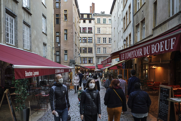 Personas con mascarilla para protegerse del coronavirus pasan frente a restaurantes el sábado 10 de octubre de 2020 en el centro de Lyon, Francia. 