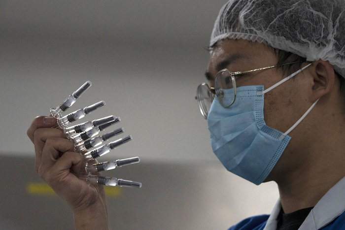 En esta foto del 24 de septiembre de 2020, un empleado inspecciona jeringas para la vacuna contra la COVID-19 producida por Sinovac en su fábrica de Beijing. 