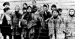 En esta imagen tomada justo después de la liberación por parte del ejército soviético en enero de 1945, un grupo de niños con los uniformes de campo de concentración tras una alambrada en el campo nazi de Oswiecim (Auschwitz).  Foto: CAF pap, AP. Archivo