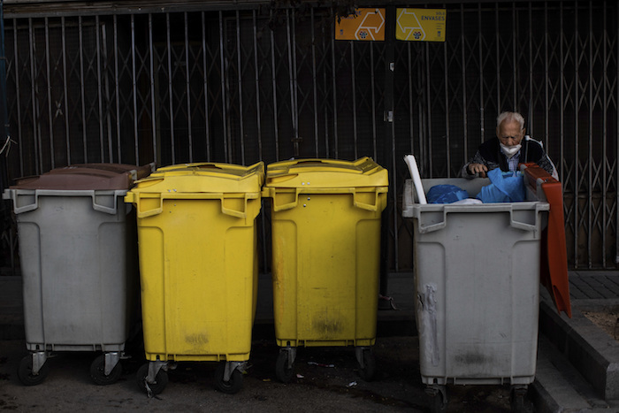 Un anciano busca en los cubos de basura en el barrio sureño de Vallecas, Madrid, España, el 1 de octubre de 2020.
