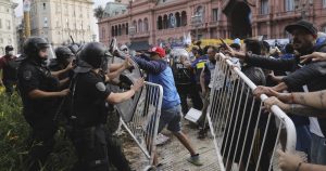 Aficionados del fútbol se enfrentan con la policía frente a la sede del gobierno, donde se realizó el velatorio de Diego Maradona, la leyenda argentino del fútbol, en Buenos Aires, Argentina. Foto: AP