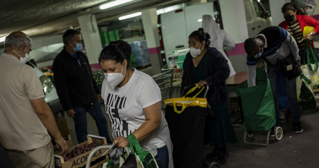 Erika Oliva, de 39 años, recoge comida donada en la congregación de las Siervas de Jesús en Madrid, España, el jueves 8 de octubre de 2020. Oliva pasa al menos tres horas a la semana haciendo fila ante un comedor social.