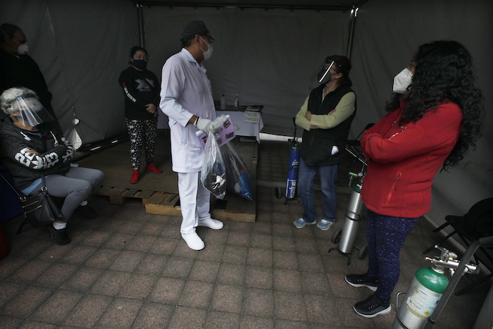 Un trabajador de salud habla con familiares de pacientes con COVID-19 que han sido dados de alta luego de recuperarse de la enfermedad en el Hospital General Ajusco Medio de la Ciudad de México, el miércoles 2 de diciembre de 2020.