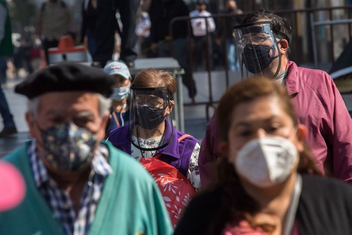 Parejas de adultos mayores utilizan cubrebocas y caretas durante su andar por el Centro Histórico de la Ciudad de México.