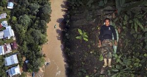 José Gregorio, líder de la Guardia Indígena del Ambiental (G.I.A.), posa para un retrato mostrando el frente de la camisa de su organización en las selvas amazónicas que rodean el río Amacuyacu a su paso por Colombia. Foto: Pablo Albarenga.

