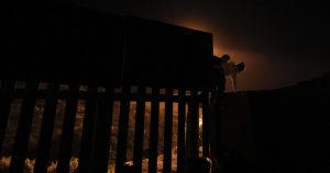 Un grupo de migrantes hondureños trepa a una parte de la valla fronteriza en la Delegación Playas de Tijuana, México, antes de entregarse a agentes migratorios de Estados Unidos. Foto: Rebecca Blackwell, AP.