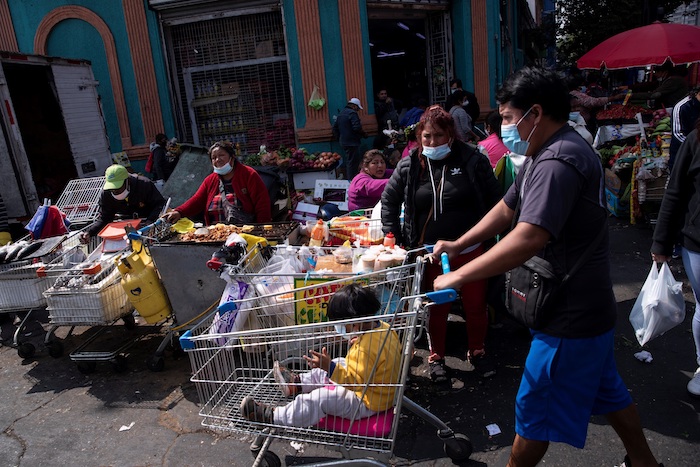 Un grupo de personas es visto hoy, en los alrededores de la Vega Central de Santiago (Chile).