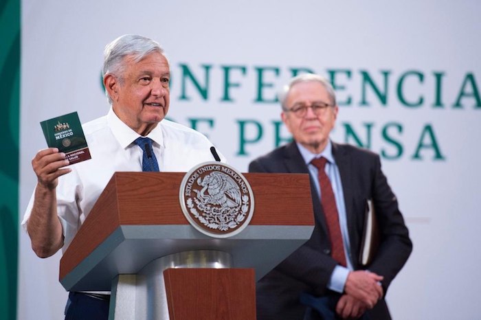 AMLO muestra su cartilla de vacunación.