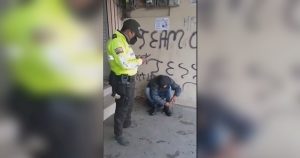 Un policía ecuatoriano le regala sus botas a un menor migrante colombiano, en el cantón Colta, Ecuador. Foto: EFE.