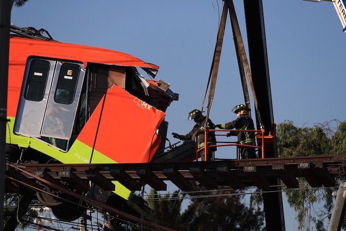 Bomberos retiran uno de los vagones del Metro de la Línea 12 que colapsaron en la noche del lunes, hoy en la Ciudad de México (México).