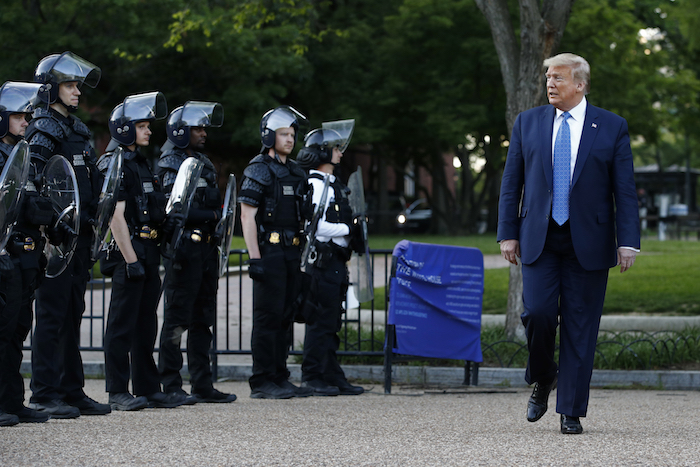En esta foto de archivo del 1 de junio de 2020, el entonces Presidente Donald Trump pasa frente a la policía en el parque Lafayette después de posar en el exterior de la iglesia de San Juan al otro lado de la plaza de la Casa Blanca, Washington.