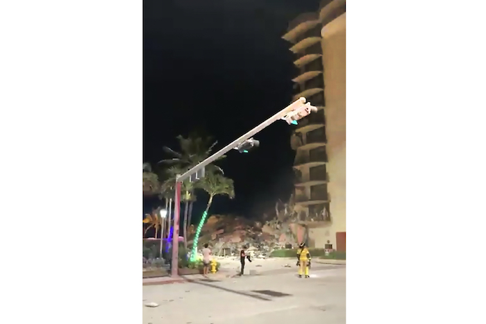En esta imagen tomada de un video, servicios de emergencia llegan al lugar donde se derrumbó parte de un edificio en Surfside, Miami, Florida, el jueves 24 de junio de 2021.
