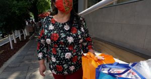 Paty, una trabajadora sexual retirada que tuvo que volver a trabajar en las calles de la Ciudad de México durante la pandemia, carga bolsas de despensas que recibió de organizaciones comunitarias. Foto: Aline Suárez del Real, GPJ Mexico.