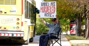 David Trujillo sostiene un letrero frente a una construcción donde opera un proveedor de abortos el jueves 7 de octubre de 2021, en Dallas, Texas. El letrero dice: "Aquí se asesina a bebés". Foto: LM Otero.