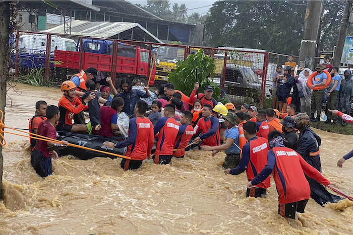 En esta imagen publicada por la Guardia Costera filipina, rescatistas asisten vecinos en una zona inundada al paso del tifón "Rai", en la ciudad de Cagayan de Oro, en el sur de Filipinas, el jueves 16 de diciembre de 2021.
