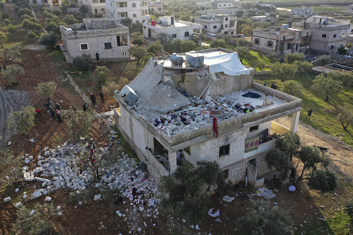 Varias personas inspeccionan una casa destruida tras una incursión del ejército estadounidense en la localidad siria de Atmeh, en la provincia de Idlib, el 3 de febrero de 2022.
