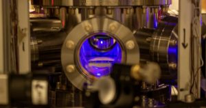 Uno de los primeros pasos en la creación de los relojes atómicos ópticos utilizados en este estudio es enfriar los átomos de estroncio hasta casi el cero absoluto en una cámara de vacío, lo que los hace aparecer como una bola azul brillante flotando en la cámara. Foto: Shimon Kolkowitz
