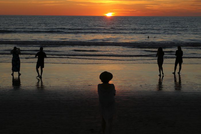 Turistas disfrutan de la vista del atardecer en la playa de Puerto Vallarta. 
