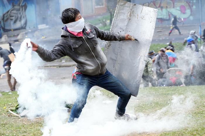 Un manifestante devuelve un bote de gas lacrimógeno durante los enfrentamientos con la policía en el centro de Quito, Ecuador, el viernes 24 de junio de 2022.