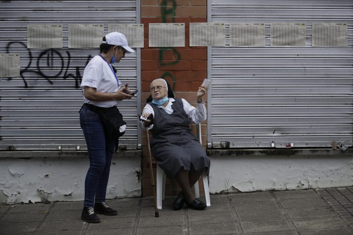 Una monja habla con una funcionaria electoral en un centro de votación durante la segunda vuelta de las elecciones presidenciales en Bucaramanga, Colombia, el domingo 19 de junio de 2022.