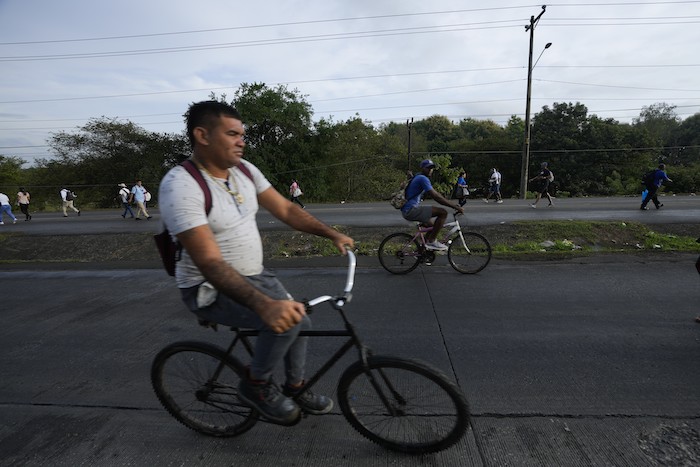 La gente anda en bicicleta y camina debido a los bloqueos de carreteras establecidos por los manifestantes que protestan contra la inflación, especialmente el aumento de los precios del combustible, en Pacora, Panamá, la madrugada del miércoles 20 de julio de 2022.
