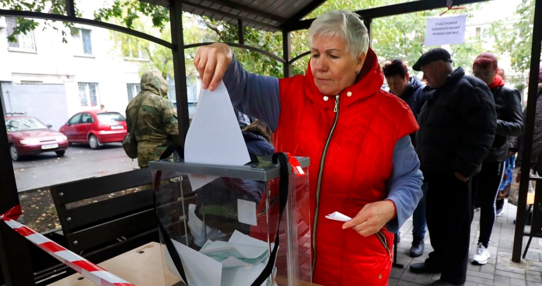 Una mujer deposita su voto durante un referéndum en una casilla electoral móvil el viernes 23 de septiembre de 2022, en Mariúpol, en la región ucraniana de Donetsk, controlada por separatistas respaldados por Rusia.