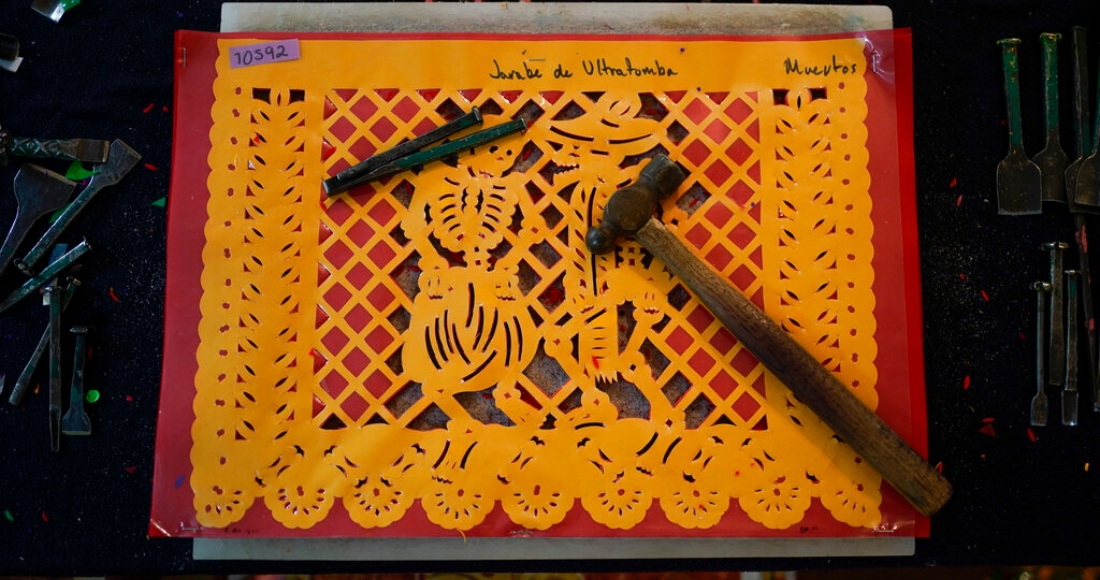 Un par de herramientas que son utilizadas para hacer "papel picado", adornos recortables de papel que han sido utilizados durante mucho tiempo en altares para el Día de Muertos, yacen encima de una plantilla en un taller en Xochimilco, una delegación de la Ciudad de México, el jueves 27 de octubre de 2022.