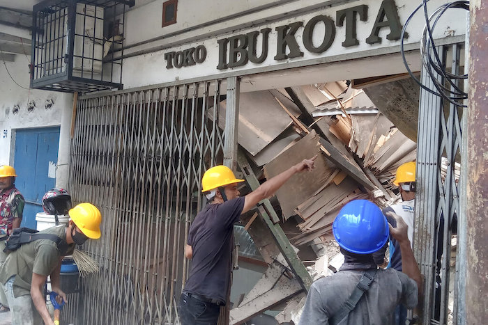 Trabajadores inspeccionan una tienda dañada durante un sismo en Cianjur, Java Occidental Indonesia, el lunes 21 de noviembre de 2022.