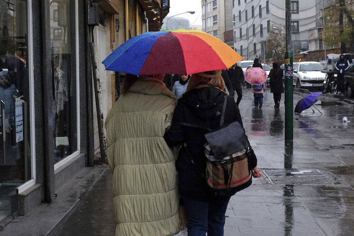 Dos mujeres se protegen de la lluvia mientras caminan en el Bazar del barrio de Tajrish, en el norte de Teherán, Irán, el lunes 5 de diciembre de 2022. 
