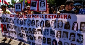 Manifestantes muestran una pancarta con retratos de mujeres asesinadas durante la dictadura militar de Augusto Pinochet, durante una marcha con motivo del Día de los Derechos Humanos, realizada en Santiago, Chile, el sábado 10 de diciembre de 2022.