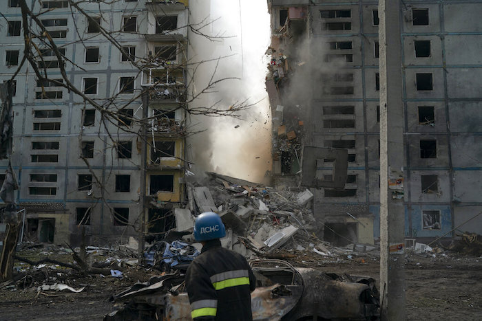 Un bombero observa cómo se derrumba parte de un muro de un edificio residencial que quedó muy dañado tras un ataque ruso en Zaporiyia, Ucrania, el 9 de octubre de 2022.