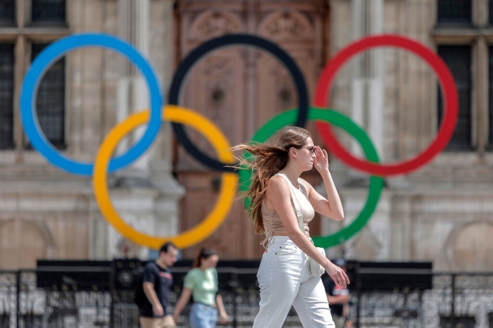 Foto del 25 de julio del 2022, una mujer pasa junto a los aros olímpicos afuera del ayuntamiento de París. El viernes 3 de febrero del 2023, Ucrania incrementa esfuerzos para vetar deportistas rusos de los Juegos Olímpicos y dice que un boicot es posible. Foto: Lewis Joly, Archivo, AP.
