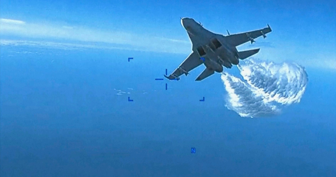En la imagen, tomada de un video distribuido el 16 de marzo de 2023, un avión Su-27 ruso se acerca a la parte trasera de un dron estadounidense MQ-9 y comienza a arrojar fuel a su paso, sobre el Mar Negro, dijo el Pentágono.