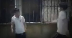 La víctima no puso ninguna resistencia, y no alcanzaba a cubrirse del violento ataque; las patadas del alumno llegaron hasta el rostro y cuello del menor, además, una vez en la reja, recibe más golpes, donde casi llega a desplomarse. Foto: Especial, captura de pantalla. 