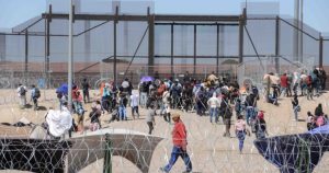 Algunos han colocado casas de acampar y otros improvisan refugios colgando mantas y cobijas del alambre de púas que ha colocado la Guarda Nacional de Texas y del muro metálico fronterizo instalado por Estados Unidos en su frontera con México. Foto: Rey R. Jauregui,  La Verdad. 