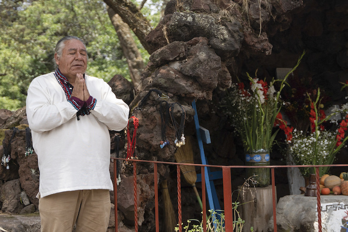 Moisés Vega agradece por los visitantes del Museo del Volcán junto a una réplica del santuario que la gente le dedica al volcán Popocatépetl, en Amecameca, México, el domingo 11 de junio de 2023.